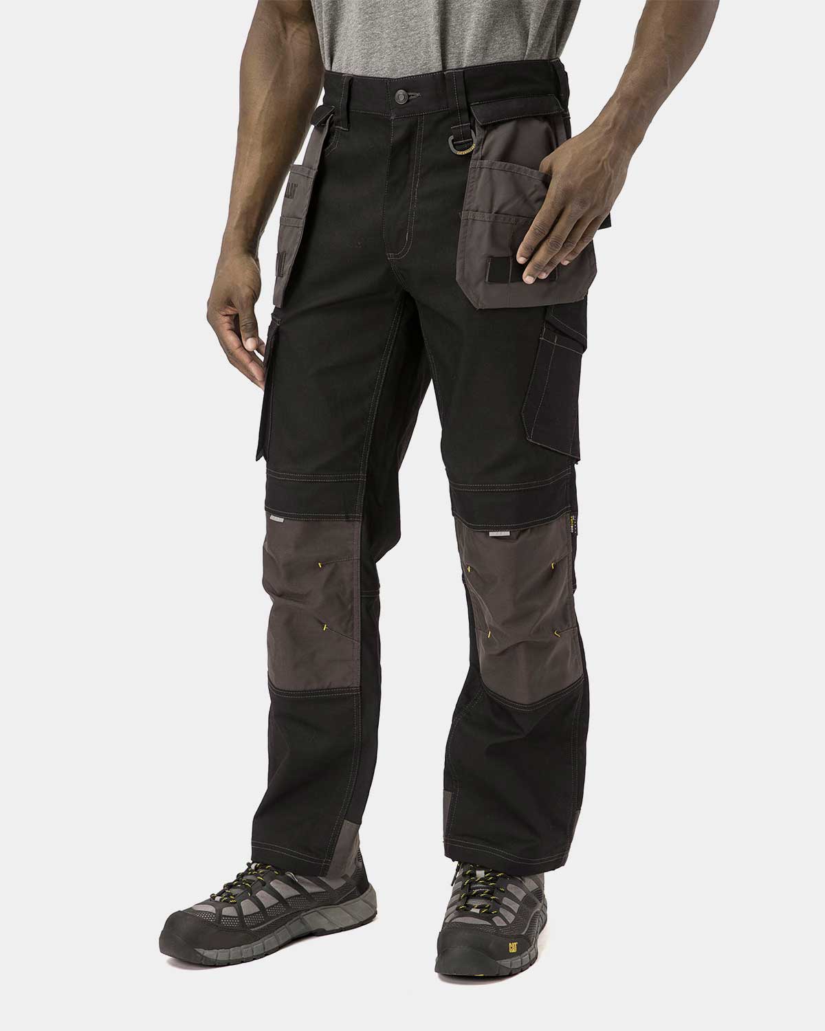 Cat Workwear Men's H2O Defender Work Pants Black on model Front with pockets pulled out, color:Black