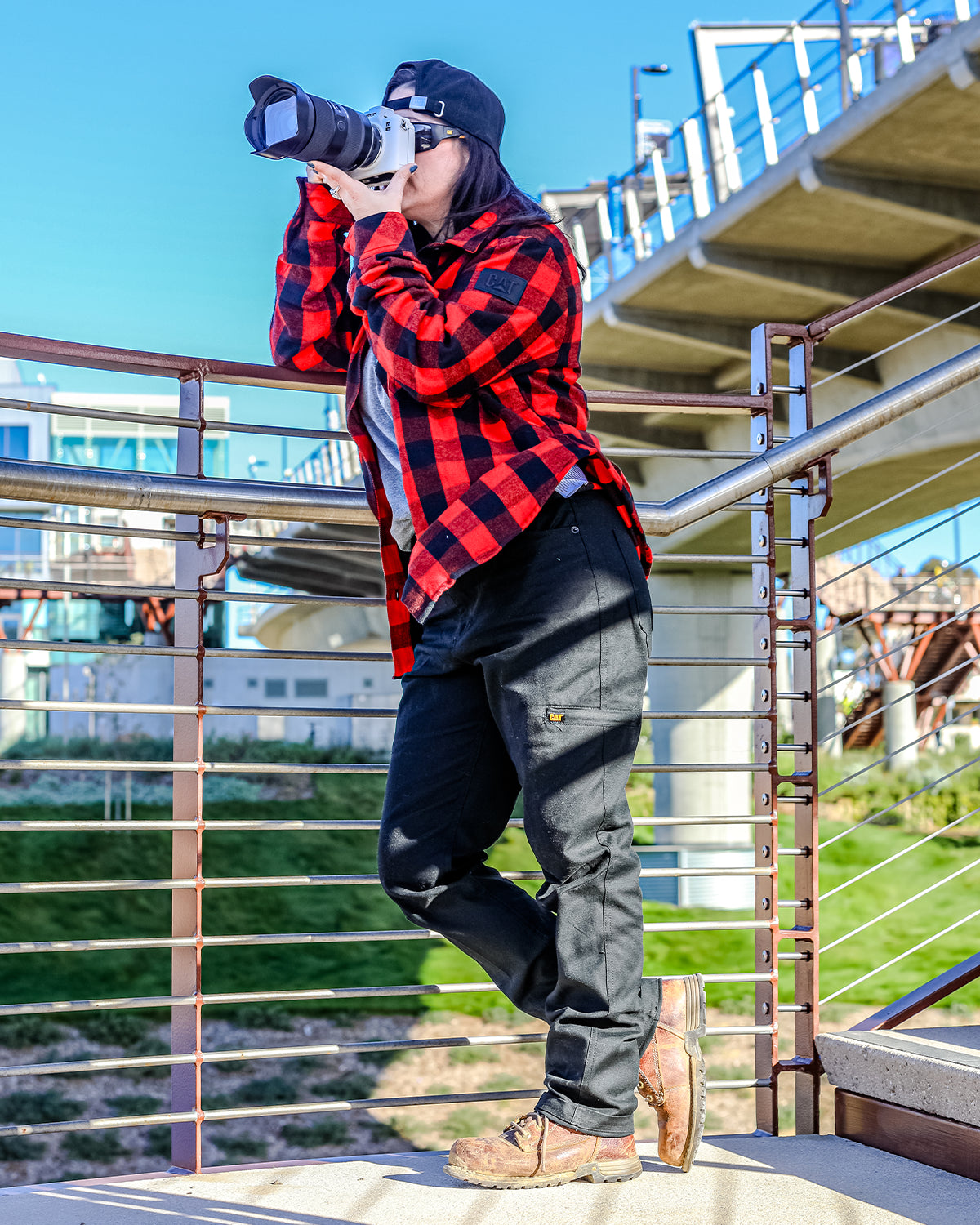 CAT WORKWEAR Women's Buffalo Check Flannel Overshirt Red Field Side Holding Camera